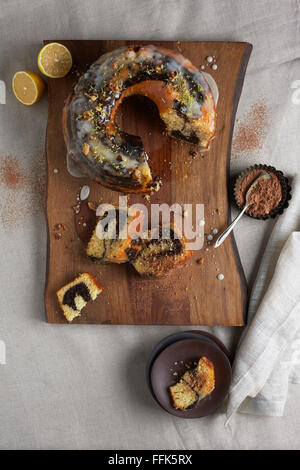 Cioccolato e limone Bundt di turbolenza la torta su una corteccia legno rivestito tagliere Foto Stock