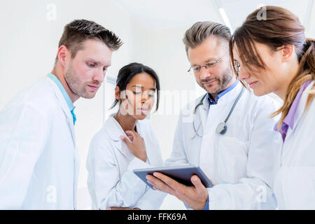 Medico e i suoi collaboratori utilizzando digitale compressa in ospedale Foto Stock