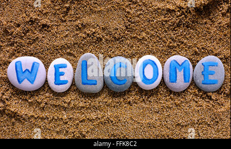 Parola magia di benvenuto fuori da pietre con le lettere sulla sabbia di mare. Lettere disegnati da me Foto Stock