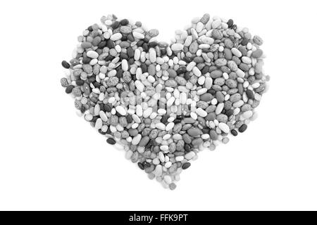 Misto di fagioli secchi in una forma di cuore, isolata su uno sfondo bianco - elaborazione monocromatica Foto Stock