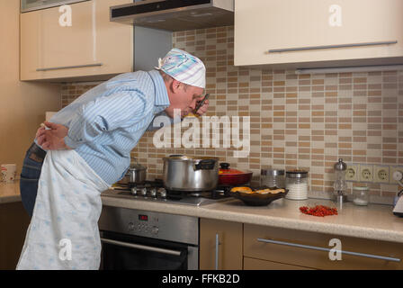 Uomo maturo degustazione borsch ucraino appena cotti se stesso per la prima volta Foto Stock