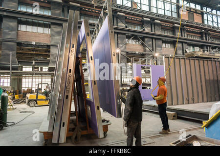 Lavoratori manovra una parete in posizione di alloggiamento modulare in una fabbrica in Brooklyn Navy Yard a New York il giovedì, 11 febbraio 2016. A causa dell aumento degli affitti e la necessità di un servizio specializzato di spazio la fabbrica sarà la chiusura dopo dopo questo processo, alloggiamento per la molla di Neemia Creek allo sviluppo. Steiner Studios, un altro locatario presso il Brooklyn Navy Yard sarà tenuto oltre lo spazio. (© Richard B. Levine) Foto Stock