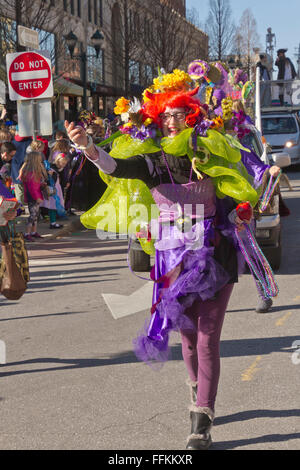 Un colorato costume donna in un Mardi Gras Parade getta in plastica colorata perle per gli spettatori Foto Stock