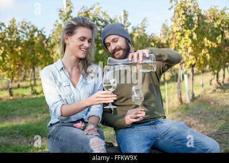 Paio di bere il vino bianco garden party in vigna Foto Stock