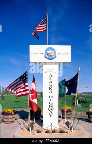 Delta giunzione, Alaska, Stati Uniti d'America - Miglio 1422, fine dell'Alaska Highway Signpost circondato dagli americani, canadesi e bandiere in Alaska Foto Stock