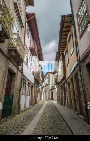 Facciate ed edifici medievali e vicolo vicino alla piazza di Santiago, noto anche come Sao Tiago o Sao Thiago, nel centro storico di C Foto Stock