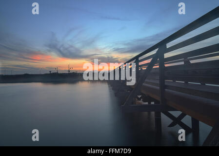 Passerella in legno al tramonto, per viaggio attraverso Bolsa Chica zone umide di preservare in Huntington Beach, California, Stati Uniti Foto Stock