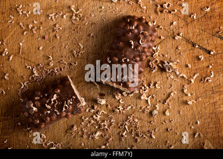 Barra di cioccolato con caramello e dado con wafer su sfondo di legno Foto Stock