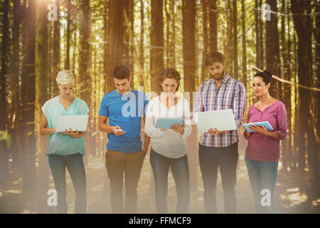 Immagine composita del gruppo di giovani colleghi utilizzando laptop e tablet Foto Stock