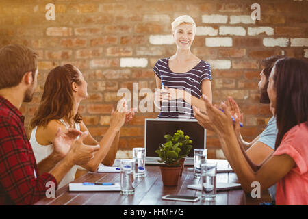 Immagine composita di colleghi battendo le mani in una riunione Foto Stock