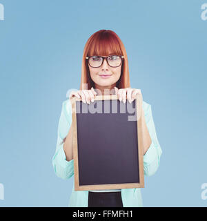 Immagine composita di sorridere hipster donna holding di Blackboard Foto Stock