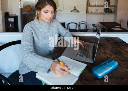 Giovane donna attraente facendo il suo dovere in cafe Foto Stock