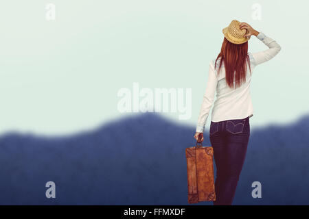Immagine composita della vista posteriore del hipster donna valigia di contenimento Foto Stock