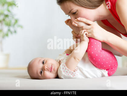 Felice madre divertendosi con il suo bambino neonato Foto Stock