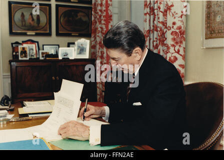 Nov. 22, 2009 - Washington, Distretto di Columbia, Stati Uniti d'America - il Presidente degli Stati Uniti Ronald Reagan segni H.J. Risoluzione 523 nel suo studio nella Residenza della Casa Bianca di Washington, DC il Venerdì, Aprile 1, 1988. La risoluzione prevede un trasferimento di 47,9 millionÂ dollari degli Stati Uniti dal Dipartimento della Difesa USA (DoD) per l'Agenzia per lo Sviluppo Internazionale (aiuto), maggiorato di un determinato importo per i costi di trasporto associati alla fornitura di assistenza per sostenere la pace e la democrazia in America centrale.Mandatory Credit: Bill Fitz-Patrick - White House via CNP (Credi Foto Stock