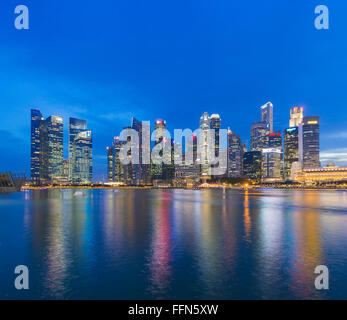 Lo skyline di Singapore attraverso Marina Bay, Singapore, Sud-est asiatico di notte Foto Stock