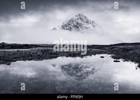 Il picco di Buachaille Etive Mor e la sua riflessione in una nebbiosa mattina nel fiume etive Foto Stock