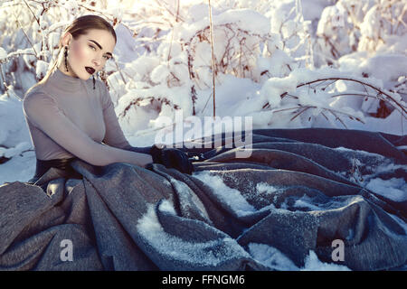 La regina delle nevi. Giorno d'inverno. Abito di lusso. La bambina in mezzo alla neve. Orecchini di nero. Foto Stock