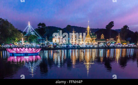 Tempio da un lago dopo il tramonto a Mae Hong Son, Thailandia Foto Stock