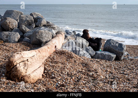 Coppia giovane seduto su southsea spiaggia accanto alla solent England Regno Unito Foto Stock