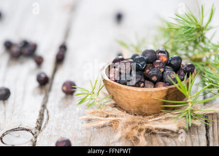 Essiccato bacche di ginepro su sfondo di legno (close-up shot) Foto Stock