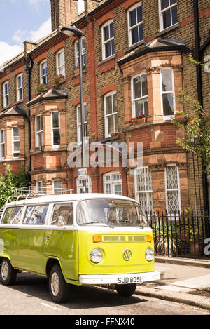 Vecchio verde vintage van parcheggiato in una strada con case in stile vittoriano in background Foto Stock