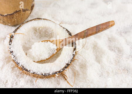 Dimezzato cocco fresco e polvere di noce di cocco sul tavolo Foto Stock