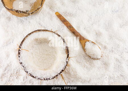 Dimezzato cocco fresco e polvere di noce di cocco sul tavolo Foto Stock