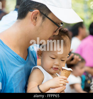 Padre e figlio sono mangiare gelati su vacanze estive. Candide foto di famiglia. Foto Stock