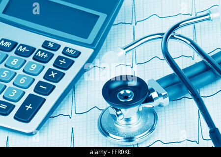 Elettrocardiografo noto anche come un elettrocardiogramma o ECG grafico con uno stetoscopio e calcolatrice che mostra il costo elevato di assistenza sanitaria Foto Stock