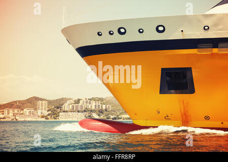 Grande giallo traghetto passeggeri nave va sulla velocità nel Mare Mediterraneo. Frammento di prua. Vintage tonale filtro di correzione, vintage s Foto Stock