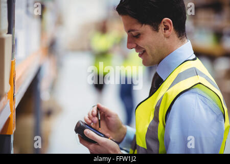 Lavoratore di magazzino tramite scanner a mano Foto Stock