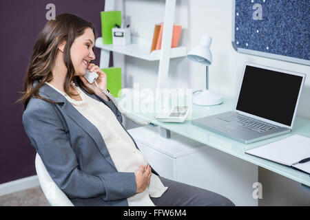 Donna incinta sul telefono Foto Stock