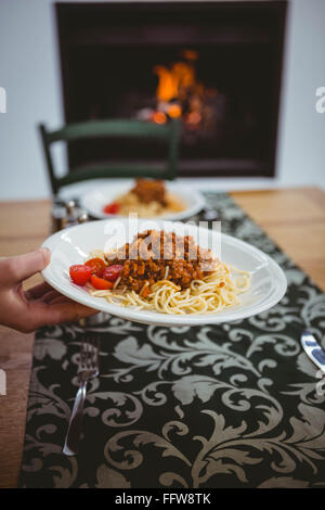 Persona di mettere gli spaghetti su tavola Foto Stock