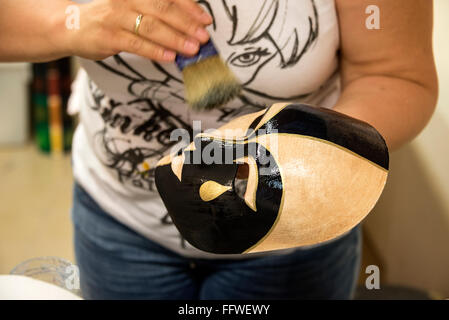 Un artista dipinge a mano una maschera per un costumista in un negozio/studio d’arte fatto a mano chiamato ‘Ca’ Macana’ in una strada stretta, chiamata Dorsoduro, Foto Stock