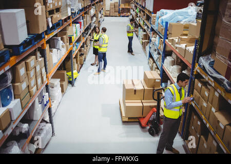 Lavoratore di magazzino tramite scanner a mano Foto Stock