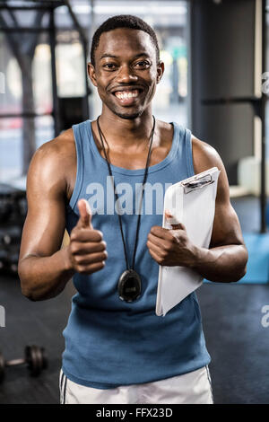 Trainer sorridente mostra pollice in alto Foto Stock