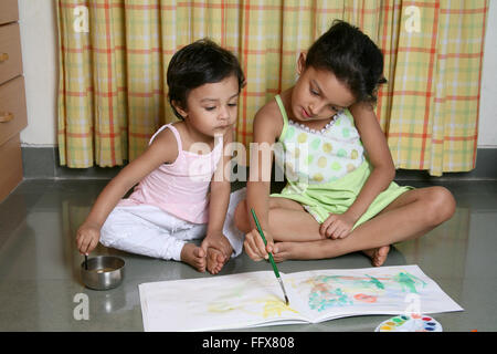 South Asian Indian due ragazze disegno sul libro di disegno con colori acqua signor# 687e 687K Foto Stock