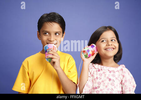 Dieci e otto anni che un ragazzo e una ragazza parlando sul bambino del telefono del fatto di due bicchieri e filo signor#703U, 703V Foto Stock