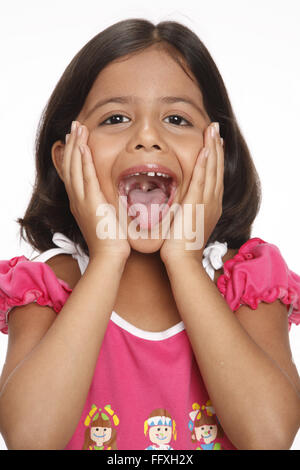 8 anno vecchia ragazza mantenuto la sua mano entrambe le palme sulle guance che mostra la tignola wide open signor#703U Foto Stock