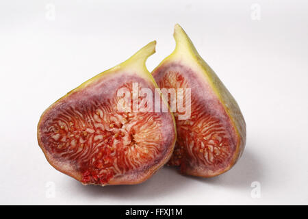 Frutta , uno Fig Ficus carica Anjir tagliato in due pezzi su sfondo bianco Foto Stock