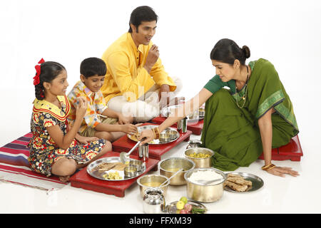 Padre e due bambini a mangiare cibo e servizio di madre in figlia signor#743A,743b,743C,743D Foto Stock