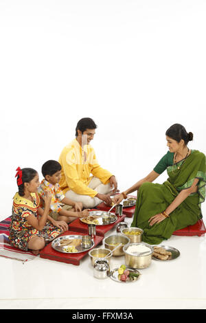 Padre e figli a mangiare cibo e servizio di madre in figlio signor#743A,743b,743C,743D Foto Stock
