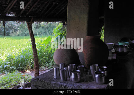 Acqua potabile in pentola di creta con acciaio inossidabile bicchieri in Orissa India Foto Stock