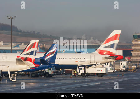 Code di aeroplani schierate sul piazzale dell'aeroporto di Aberdeen - Scozia, Regno Unito. Foto Stock