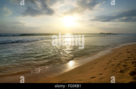 Splendido tramonto sulla spiaggia di sabbia di oceano Indiano Foto Stock