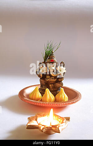 Festival indiano Ganesh chaturthi celebrazione idolo di elefante ganpati intitolata Dio nella piastra di sfondo diya Mumbai Maharashtra Foto Stock