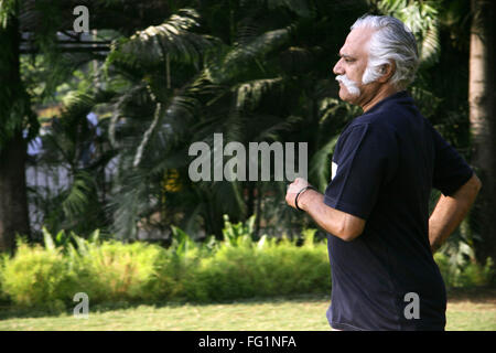 Anziano gentiluomo oltre sessanta anni in blu scuro T shirt jogging in un parco per mantenere se stesso montare signor#671 Foto Stock