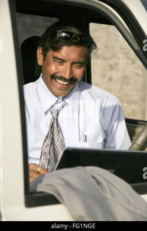 Commerciante indiano in azzurro shirt & tie seduti in auto e utilizzando laptop signor#686B Foto Stock