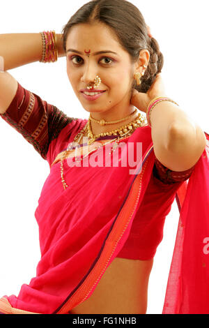 South Asian Indian Maharashtrian ragazza indossando il tradizionale navwari sari appropriate jewelry cercando regolare i capelli lunghi Foto Stock